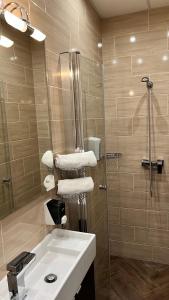 uma casa de banho com um lavatório branco e um chuveiro em Central Hotel 21 and Apartments em Budapeste
