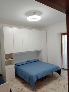 een slaapkamer met een bed en witte kasten bij Bici Grill Decimo Miglio in Ciampino