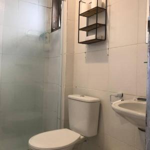 a white bathroom with a toilet and a sink at Casa no paraíso Búzios! in Búzios