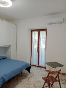 Schlafzimmer mit einem Bett, einem Tisch und einem Fenster in der Unterkunft Bici Grill Decimo Miglio in Ciampino