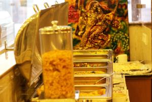 un buffet con vassoi di cibo su un bancone di OPO Hotel Viva Palace a Nuova Delhi