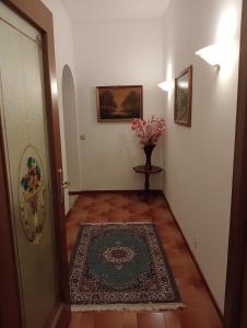 een hal met een vaas met bloemen naast een deur bij Bici Grill Decimo Miglio in Ciampino