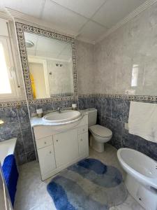 bagno con lavandino, servizi igienici e specchio di Casa Amarela Guesthouse, Algorfa ad Algorfa