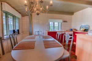 a kitchen with a table with chairs and a chandelier at Friesenhaus Sara S2 in Wenningstedt