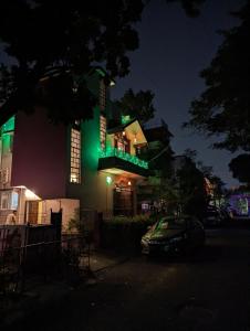 ein Haus mit grüner Beleuchtung an der Seite in der Unterkunft Guten Tag Kolkata in Kalkutta