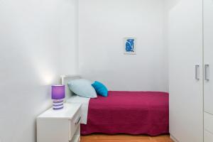 Dormitorio blanco con cama con manta morada en Center of Fažana Apartments Katarina, en Fažana
