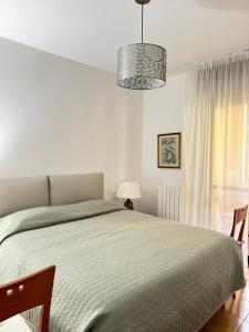 a white bedroom with a large bed and a window at Casa vacanze 1702, con la camera matrimoniale con il bagno privato e un soggiorno comune in Milan