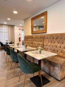 a restaurant with tables and chairs and a mirror at Hotel Don Rodrigues in Tavira