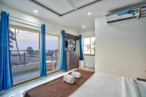 sypialnia z łóżkiem i dużym oknem w obiekcie Hotel Antonio's Nr Calangute Beach w mieście Calangute