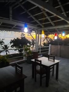 a table and chairs on a patio with a view of the ocean at White Surfing Beach Resort in Unawatuna