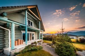 a house with the sunset in the background at Luxusní srub u Rájeckých Teplic in Stránske