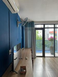 a living room with a mirror and a blue wall at Red Bean Hotel in Thuan An