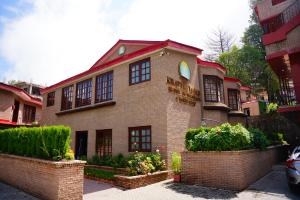 a large brick house with windows on a street at Khattak Lodge Murree in Murree