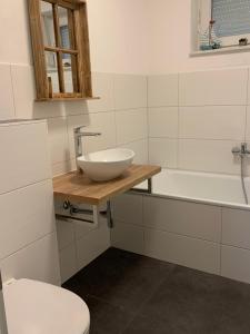 a bathroom with a sink and a toilet and a tub at Boddenhus Loissin in Loissin +33 photos