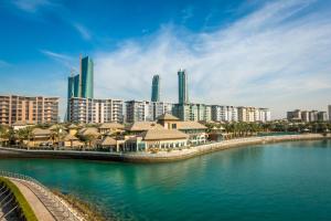 a city with tall buildings and a body of water at Palavra Resort in Manama