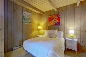 a bedroom with a bed in a wooden wall at North Conway Condo in North Conway