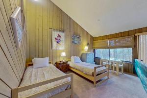 a bedroom with two beds and a desk and a window at North Conway Condo in North Conway +36 photos