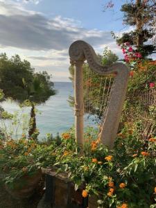 eine Statue einer Harfe in einem Garten mit Blumen in der Unterkunft Paraíso Costa Dorada in Tarragona