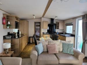 a living room with a couch and a kitchen at New Forest 2-Bed Premium Holiday Home, Hoburne Bashley Holiday Park,New Milton, Park Leisure Pass at an additonal cost in New Milton