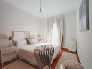 a white bedroom with a bed and a window at Duodecima in Las Palmas de Gran Canaria +24 photos