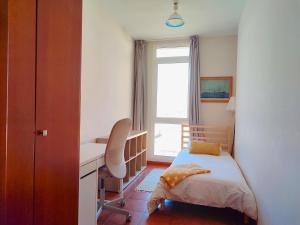 a bedroom with a bed and a desk and a window at Duodecima in Las Palmas de Gran Canaria
