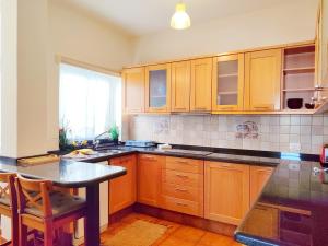 a kitchen with wooden cabinets and a table in it at Duodecima in Las Palmas de Gran Canaria