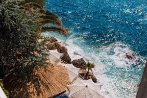an aerial view of the ocean with umbrellas at Hotel Liro - Adults Only in Vlorë