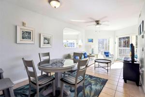 a dining room and living room with a table and chairs at Sunset Vistas 206S in St. Pete Beach