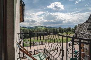 a balcony with chairs and a view of a park at Biały Dunajec Resort & Spa in Biały Dunajec