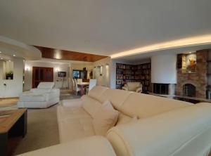 een woonkamer met witte meubels en een open haard bij Bungalow 