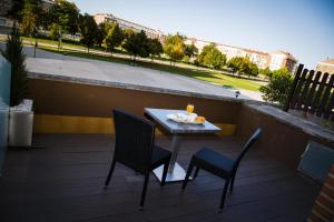einen Tisch und Stühle auf einem Balkon mit Aussicht in der Unterkunft Hotel Los Braseros in Burgos