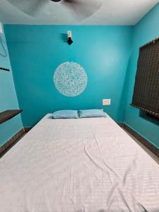 ein Schlafzimmer mit einem großen Bett mit blauer Wand in der Unterkunft New Ananda lodge in Vriddhāchalam