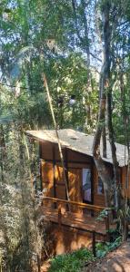 una cabaña en el bosque con un árbol en TreeHouse Seu Paraíso nas Montanhas, en Marechal Floriano