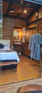 sypialnia z łóżkiem i szklaną ścianą w obiekcie TreeHouse Seu Paraíso nas Montanhas w mieście Marechal Floriano