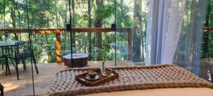 a room with a table and a large window at TreeHouse Seu Paraíso nas Montanhas in Marechal Floriano