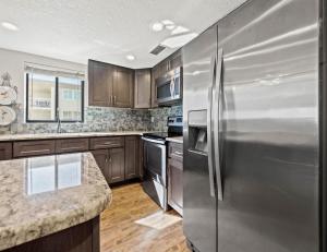 a kitchen with stainless steel appliances and wooden cabinets at Arie Dam 404 in St. Pete Beach