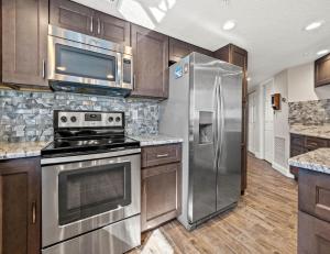 a kitchen with a stainless steel refrigerator and a microwave at Arie Dam 404 in St. Pete Beach