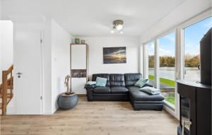 a living room with a black leather couch and a window at Beautiful Home In Tossens With Lake View in Tossenserdeich