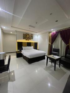 a hotel room with a bed and a table and chairs at شقق توليب الروضه للشقق المخدومة in Riyadh