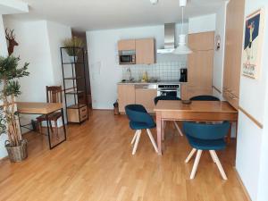 a kitchen and dining room with a wooden table and chairs at Panorama Spa Lodges DAS.SCHILLER in Bad Gastein