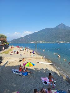 a group of people sitting on a beach at LakeView LakeComo 4Seasons, Terrace, 30m to Lake! by STAYHERE-LAKECOMO in Acquaseria