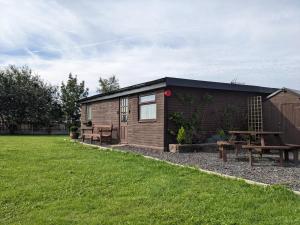 eine Blockhütte mit einem Picknicktisch und einer Picknickbank in der Unterkunft Log cabin with secure garden in Haxey