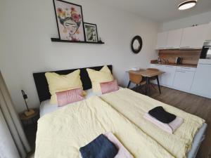 um quarto com uma cama grande com almofadas cor-de-rosa e amarelas em CASA FRIDA-Zentral-Outlet-Aufzug-Stylisch-Unique em Metzingen