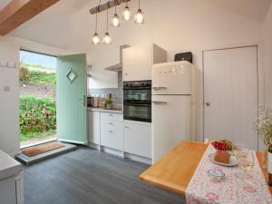 cocina con nevera blanca y mesa en Meadow View - Uk44608, en Carnbrea