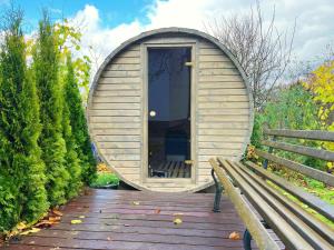 a circular building with a bench on a wooden deck at Apartamenty Przylesie in Polanica-Zdrój