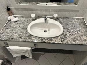 Un mostrador de baño con un lavabo blanco. en Lakeside Manor Hotel en Virginia