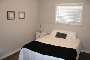 a bedroom with a bed with a black and white blanket at Freshly Updated 3 Bedroom Townhome in Lethbridge