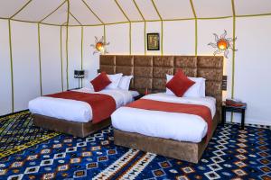 2 camas en una habitación con tienda de campaña en Yakout Merzouga Luxury Camp en Merzouga