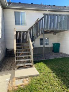 a wooden staircase in front of a house at Freshly Updated 3 Bedroom Townhome in Lethbridge