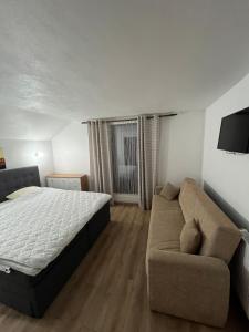 a bedroom with a bed and a couch at Pensiunea Sarah - Muntele Mic in Muntele Mic +21 photos